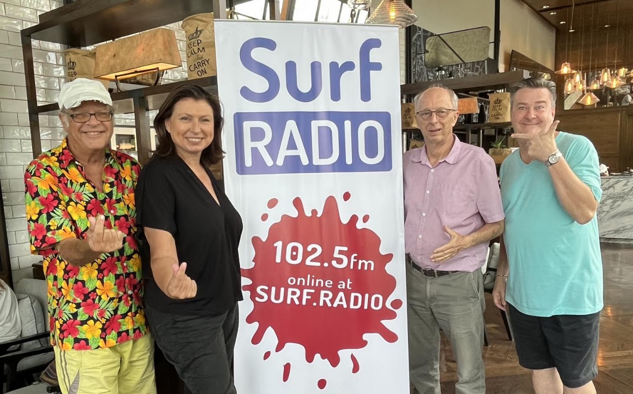 Richard Buckle with the Surf Radio team beside a Surf Radio 102.5 FM sign